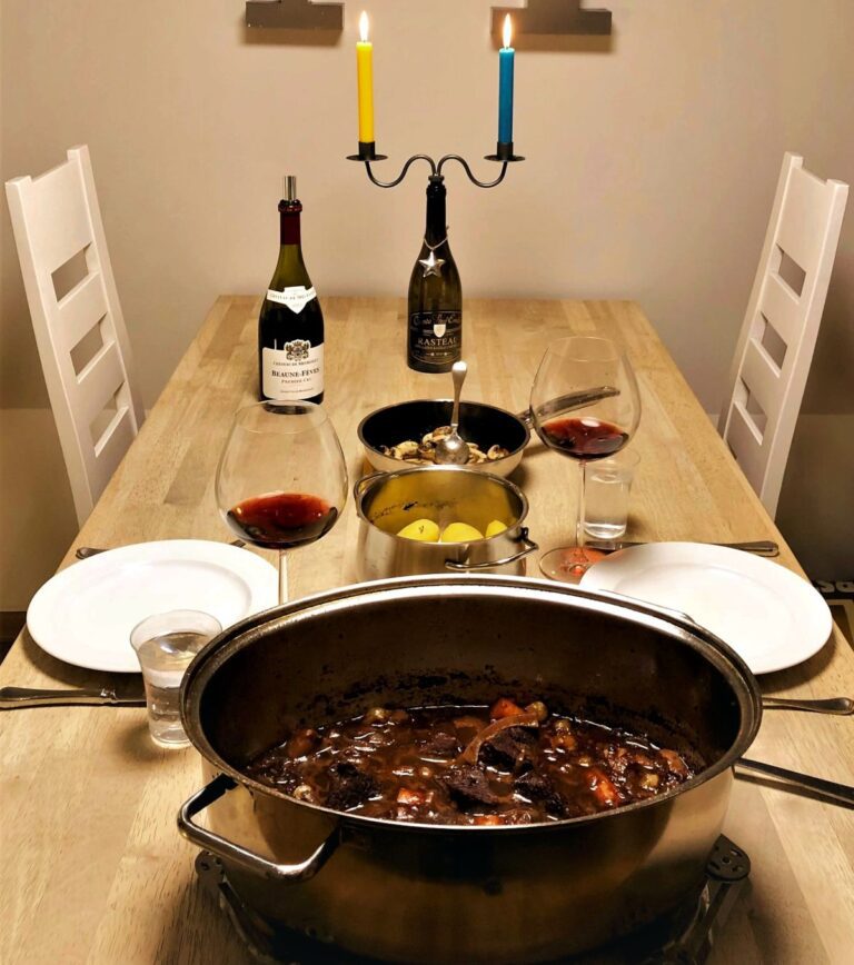 Geniessen-Boeuf-Bourgignon-im-Topf-auf-dem-Tisch-mit-Kerzen